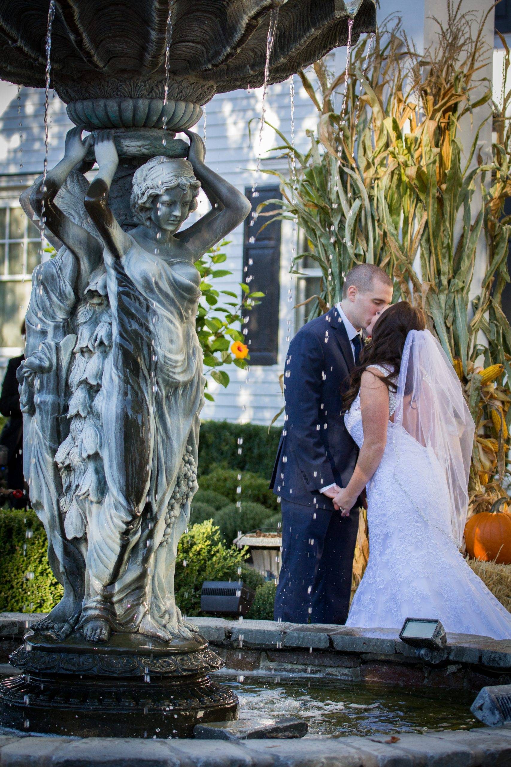 Park Savoy bride and groom kissing by fountain
