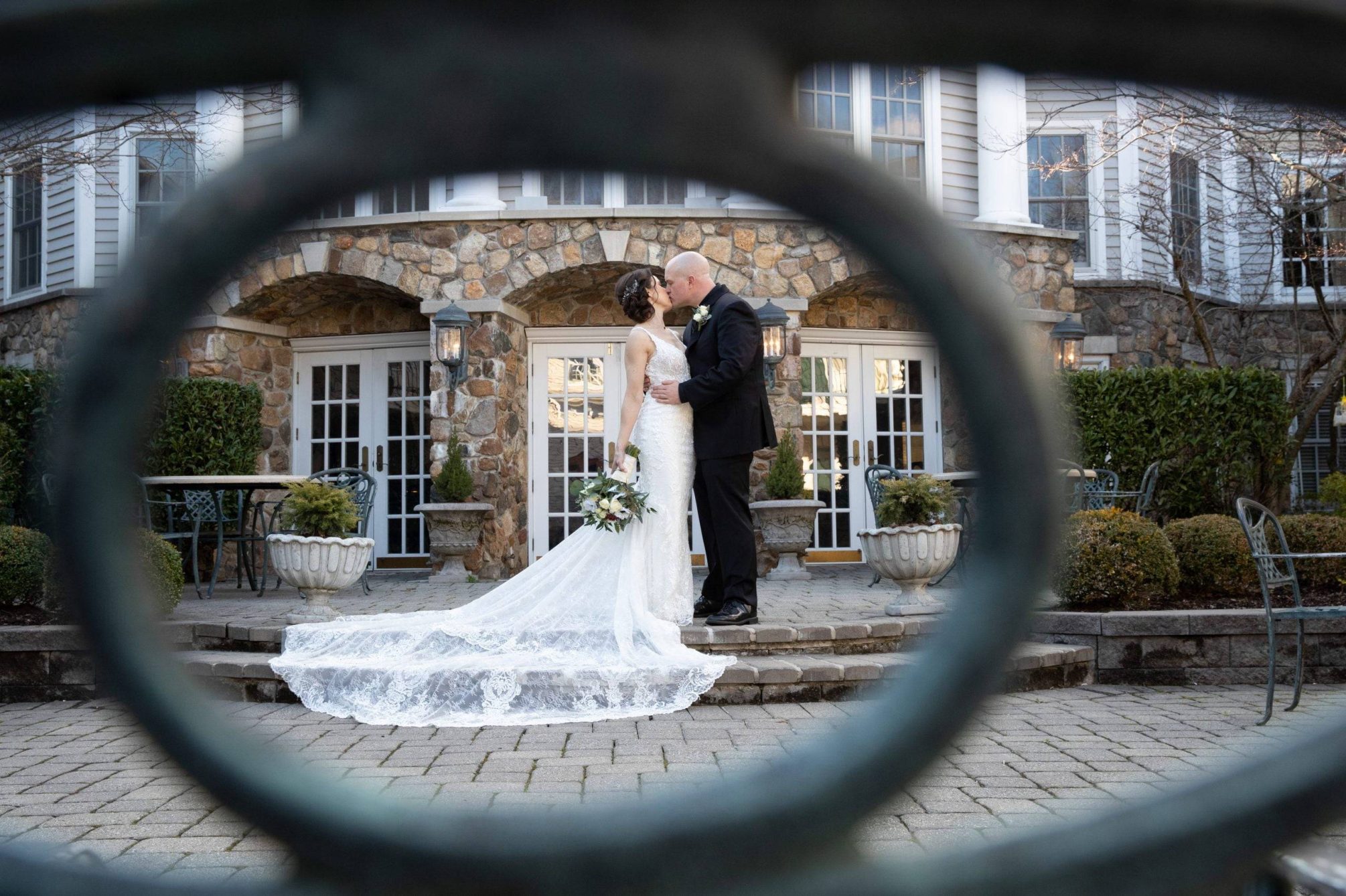 Olde Mill Inn bride and groom sneak a kiss on patio