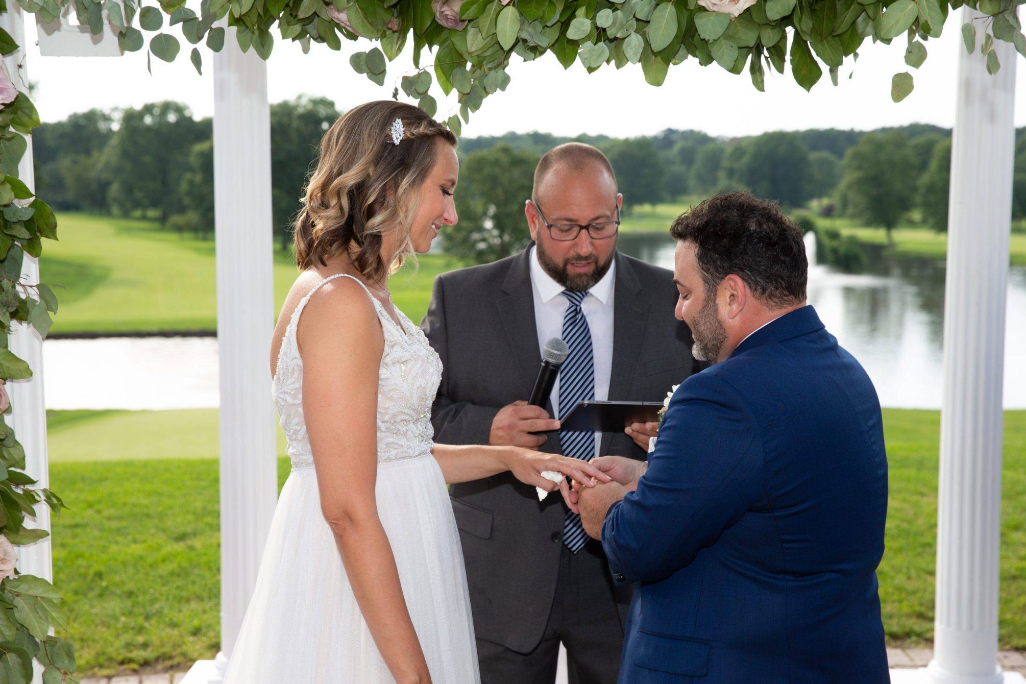 Brooklake bride and groom exchanging rings by the lake