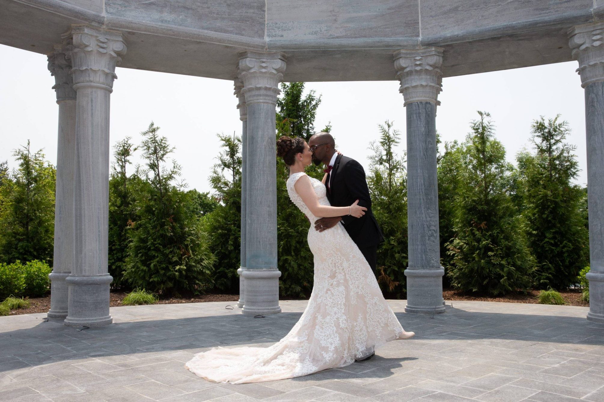 Meadow Wood wedding couple kiss outside by columns